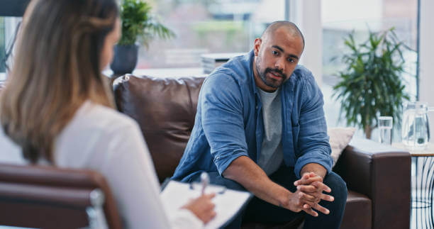 male sitting inside a clinic with a psychiatrist during a life transitions counseling